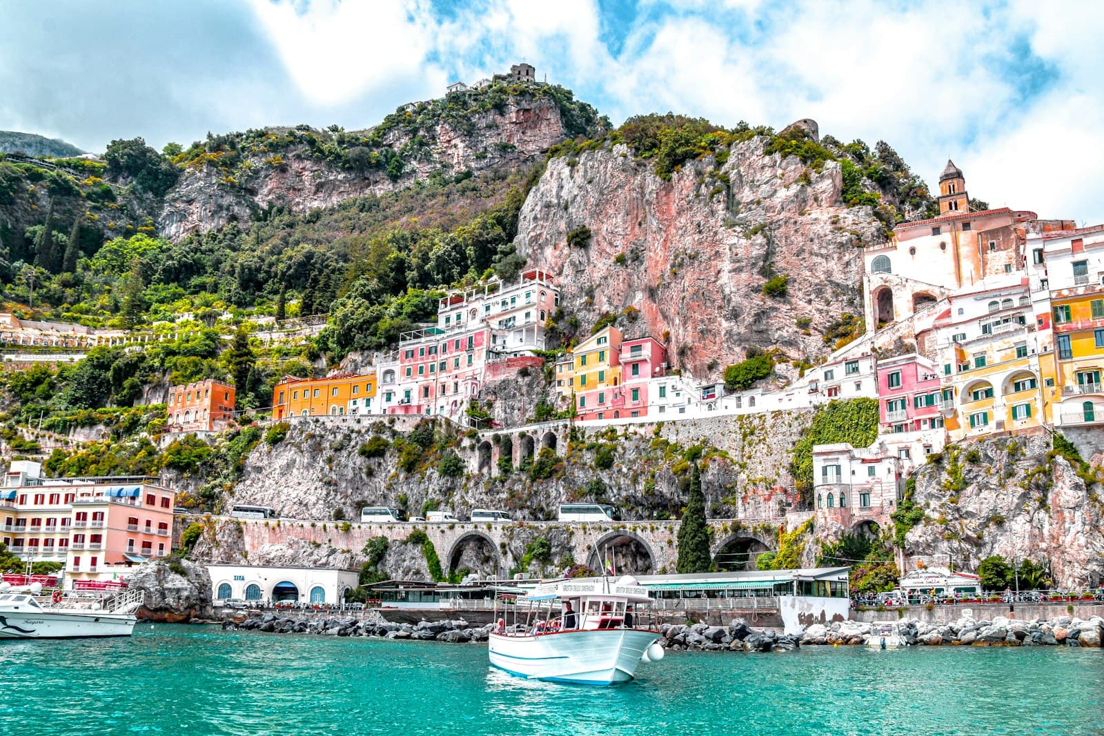 Colorful houses on a cliff above a turquoise bay on the Amalfi Coast