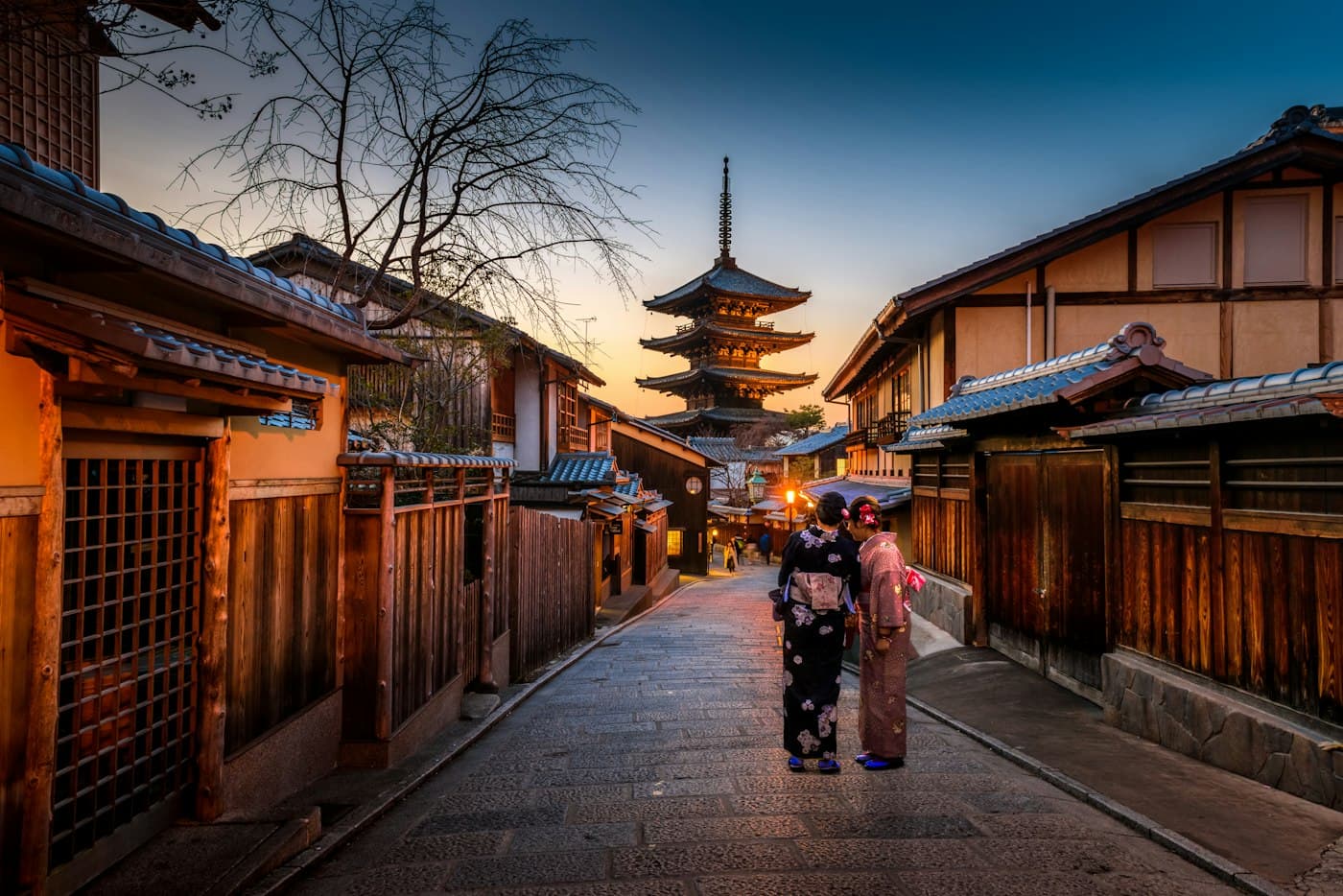 A Kyoto street at dusk with a pagoda in the distance