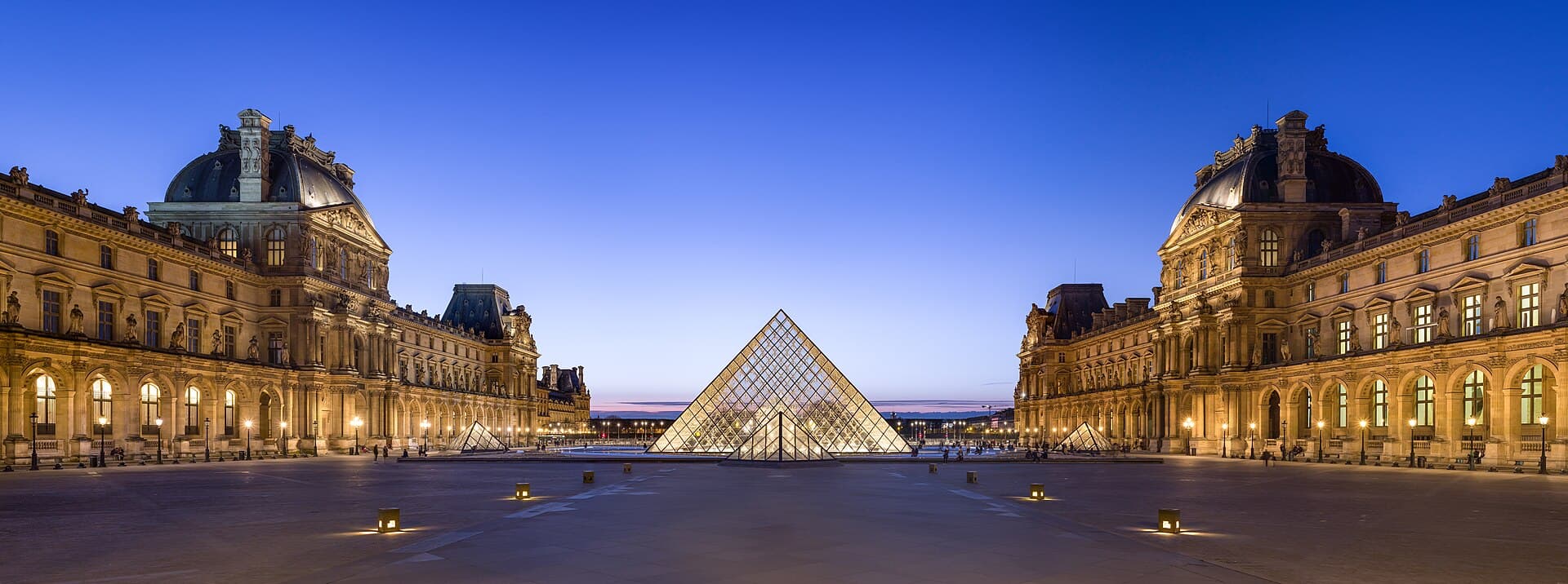 The glass pyramid in the Louvre courtyard in Paris at dusk
